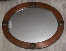 Copper Arts and Crafts mirror with hammered and riveted decoration, 62 x 51cm overall