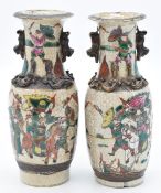 A pair of Chinese crackle glazed vases decorated with battle scenes, relief moulded lizard