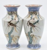 A pair of Japanese porcelain pedestal vases with enamelled decoration of swifts/swallows in