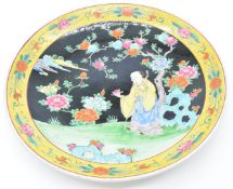 Japanese large charger depicting an elder holding a pomegranate, with impressed seal mark verso