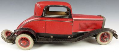 Chad Valley Ubilda clockwork tinplate Burnett two door coupé car with red and black body, 26cm long.