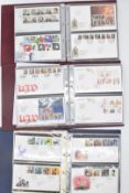 A collection of GB first day covers in ten folders, three coin covers still in packaging,