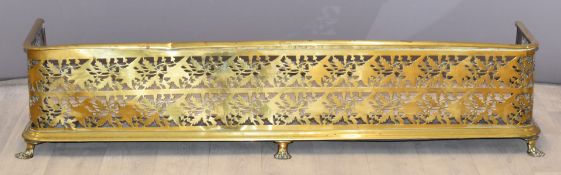 Two brass fire curbs, one raised on lion paw feet, longest 124cm