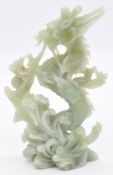 Chinese jade or similar hardstone carving of a dragon surrounded by waves, 26cm tall