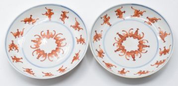 A pair of Chinese iron red and blue dishes decorated with bats, six character Guangxu marks to