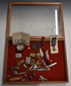 Table top display cabinet containing collectables including folding knives, enamel badges