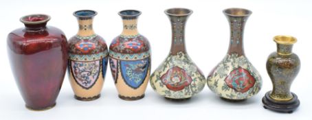 Six Japanese and Chinese vases comprising two cloisonné pairs, a Chinese example on wooden stand and