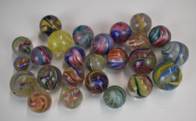 Twenty-five glass marbles all with multi-coloured latticino or onionskin decoration, largest 26mm in