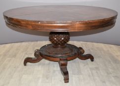 Circular mahogany extendable dining table with carved support, raised on four scrolling legs,