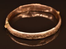 A 9ct gold bangle with engraved ivy decoration, 9.5g
