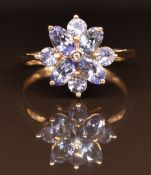A 9ct gold ring set with a diamond and tanzanites, 2.6g, size N