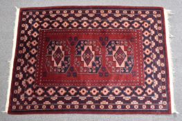 Turkoman rug burgundy ground, three guls and geometric borders, 190 x 129cm