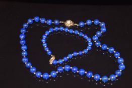 A necklace of lapis lazuli beads interspersed with gold beads, the 9ct gold clasp set with a