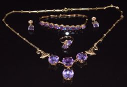 A suite of 14k gold jewellery comprising necklace, ring, bracelet and earrings all set with