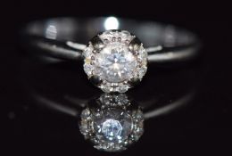 An 18ct white gold ring set with a diamond of approximately 0.2ct surrounded by further diamonds,