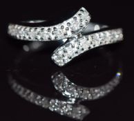 A 9k while gold ring set with diamonds in a twist setting totalling approximately 0.2ct, 3.4g,