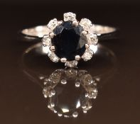 An 18ct white gold ring set with a sapphire and diamonds, 3g, size N