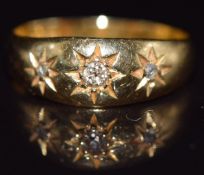 An 18ct gold ring set with three diamonds in star settings, Birmingham 1913, 2.8g, size M