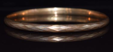 A 9ct gold flapper bangle with faceted decoration, Birmingham 1925, 7.4g, 7.6cm