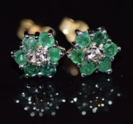 A pair of 9ct gold earrings set with a diamond and emeralds in a cluster