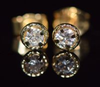 A pair of 18ct gold earrings set with a round cut diamond to each