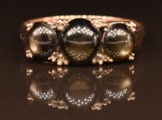 A 14k gold ring set with three black star sapphire cabochons, 2.7g, size N