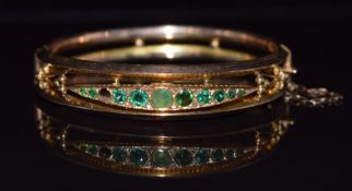 Victorian 9ct gold bangle set with emeralds and diamonds, 10.1g, 5.2 x 5cm