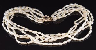 A six strand pearl necklace, the 9ct gold clasp set with a garnet cabochon ands split pearls, 40cm