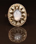 A 9ct gold ring set with a star sapphire surrounded by white sapphires, 4.2g, size L