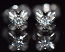 A pair of 18ct white gold earrings set with a diamond to each, 1.8g