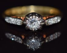An 18ct gold ring set with a diamond of approximately 0.25ct with diamond encrusted shoulders, 2.8g,