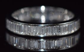 A 14k white gold eternity ring set with baguette cut diamonds, total diamond weight approximately