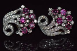 A pair of 18ct white gold earrings set with round cut rubies and round cut diamonds in a stylised