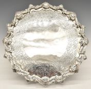 Georgian hallmarked silver salver with shaped edge and engraved decoration, raised on four feet,