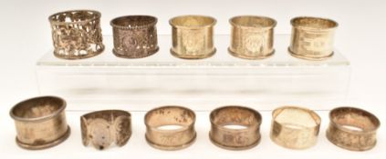 Eleven silver napkin rings comprising ten hallmarked silver and one Indian or Burmese example with