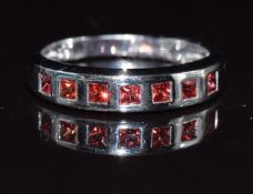 A 9k white gold ring set with orange sapphires, 2.9g, size N