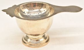 White metal tea strainer and stand or bowl, both marked 925 Sterling, length 12cm, weight 116g