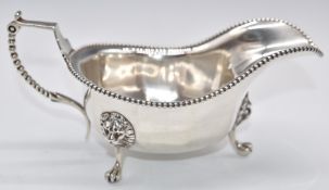 George V hallmarked silver sauce boat with beaded edge and lion mask supports to legs, London