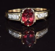 A 9k gold ring set with an oval cut red topaz and diamonds, 3.1g, size Q