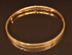 A 9ct gold flapper bangle with engraved decoration, 5.5g, 6.7cm