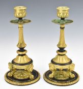 Pair of French Empire style brass candlesticks with mask decoration, raised on ball and claw feet