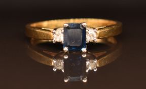 An 18ct gold ring set with an emerald cut sapphire and diamonds, size M, 2.8g