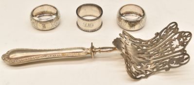 Three hallmarked silver napkin rings including a pair, weight 73g and a silver plated pierced cake