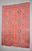 Afghan rug with red ground and repeating blue star motifs, 200 x 130cm