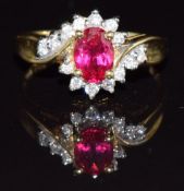 An 18ct gold ring set with an oval cut synthetic ruby and diamonds, 4g, size O