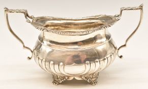 Victorian hallmarked silver twin handled sugar bowl with ornate rim, raised on lion paw feet, London