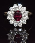 A platinum ring set with an oval cut ruby of approximately 1.6ct surrounded by diamonds, 3.7g,