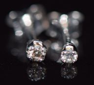 A pair of 9ct white gold earrings set with a diamond to each