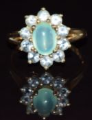 A 9k gold ring set with a quartz cabochon surrounded by topaz, 3.6g, size Q