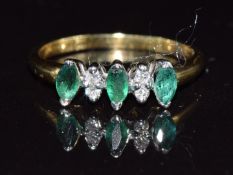 An 18ct gold ring set with marquise cut emeralds and diamonds, 3.1g, size O